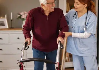 Infirmière soutenant un senior avec un déambulateur