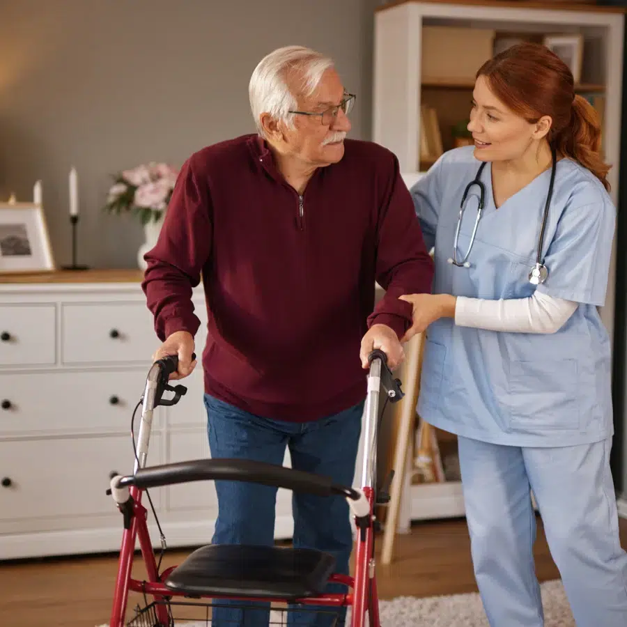 Infirmière soutenant un senior avec un déambulateur