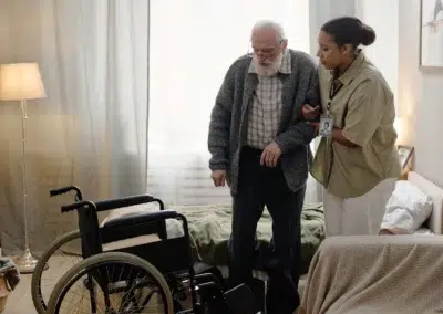Un soignant aide un senior à se déplacer.