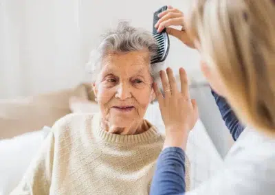 Aide-soignante coiffant une personne âgée