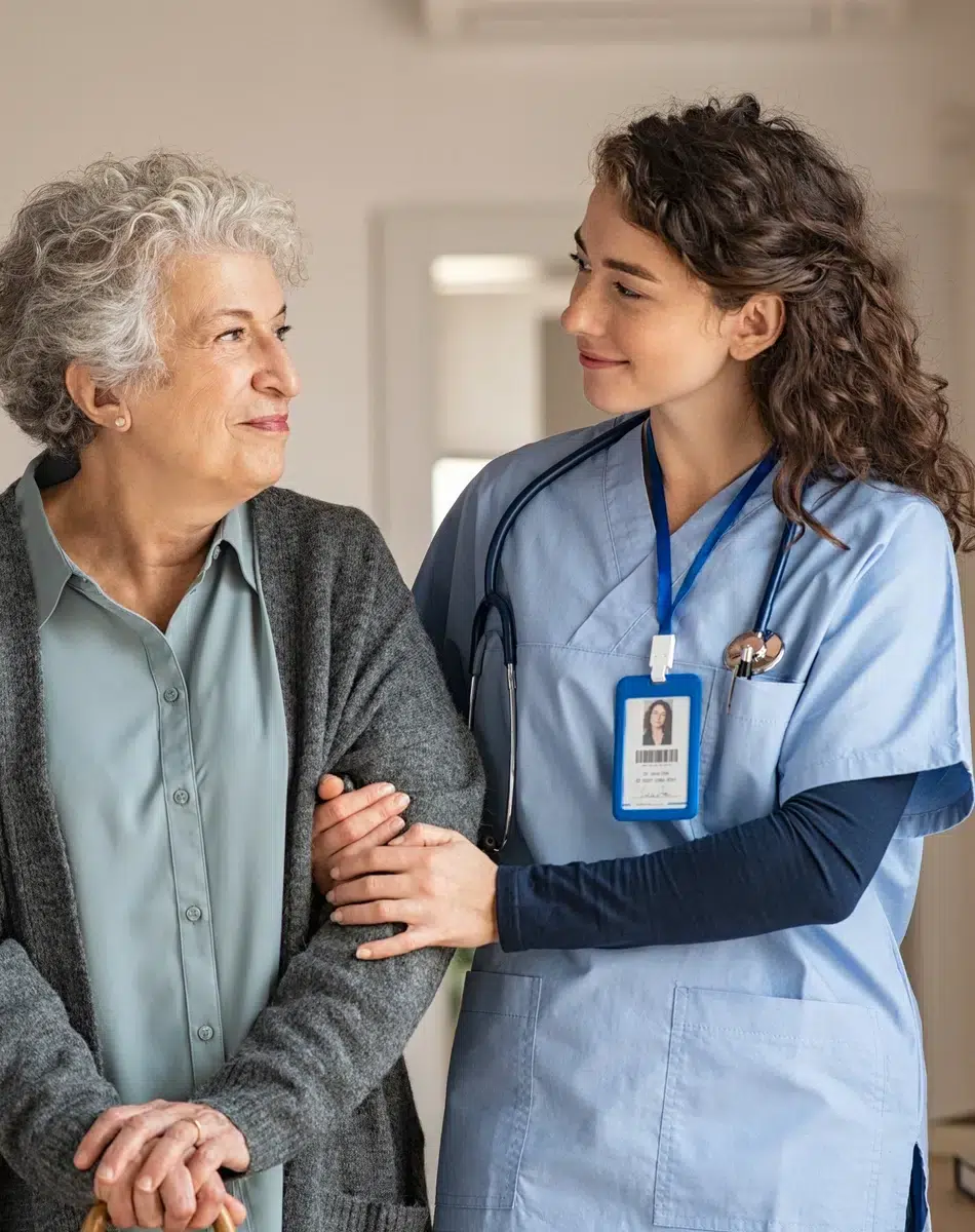 Infirmière souriante soutenant une personne âgée à domicile